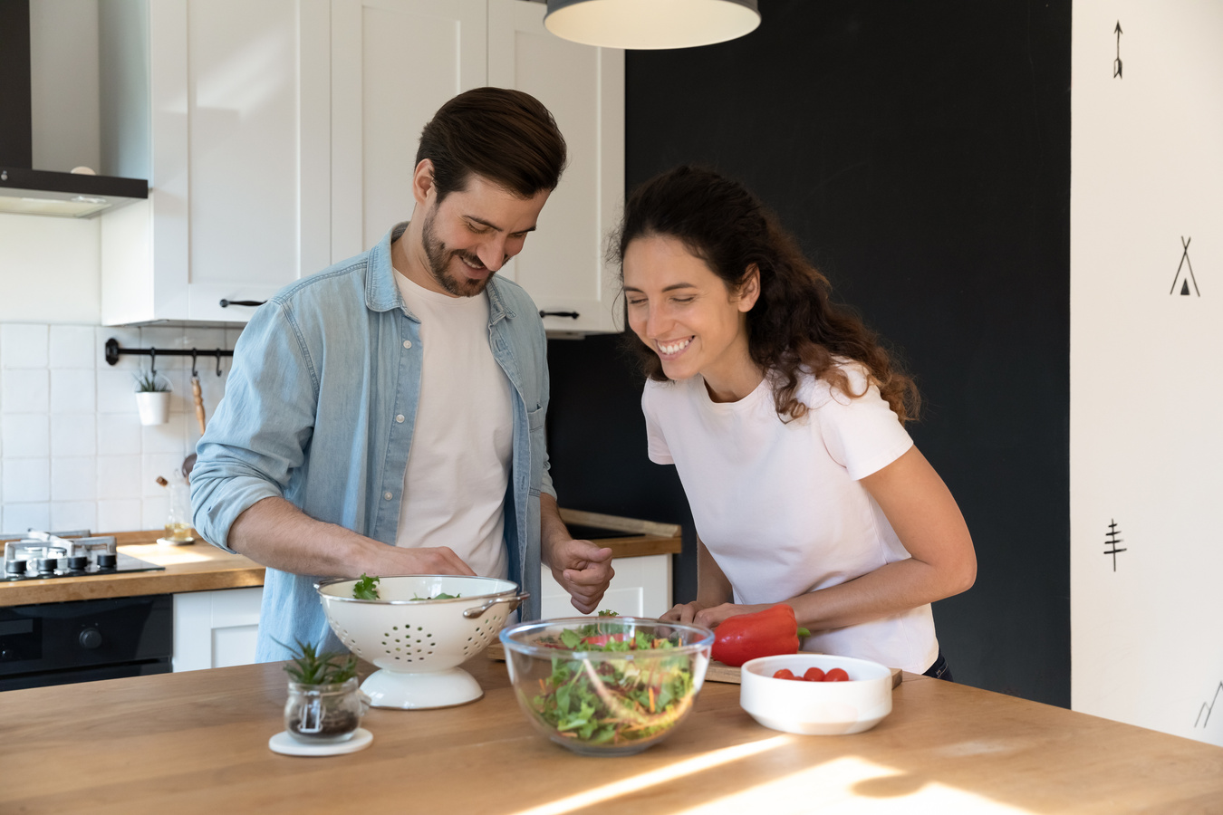 Happy couple tenants cooking together in kitchen